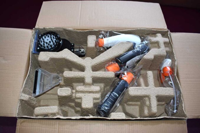 Various tools and a couple of bottles of cleaning fluid come with the carpet washer machine.